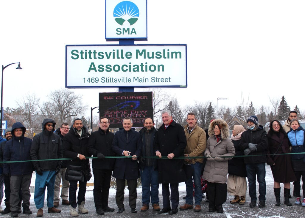 Group photo in front of the Stittsville Muslim Association sign