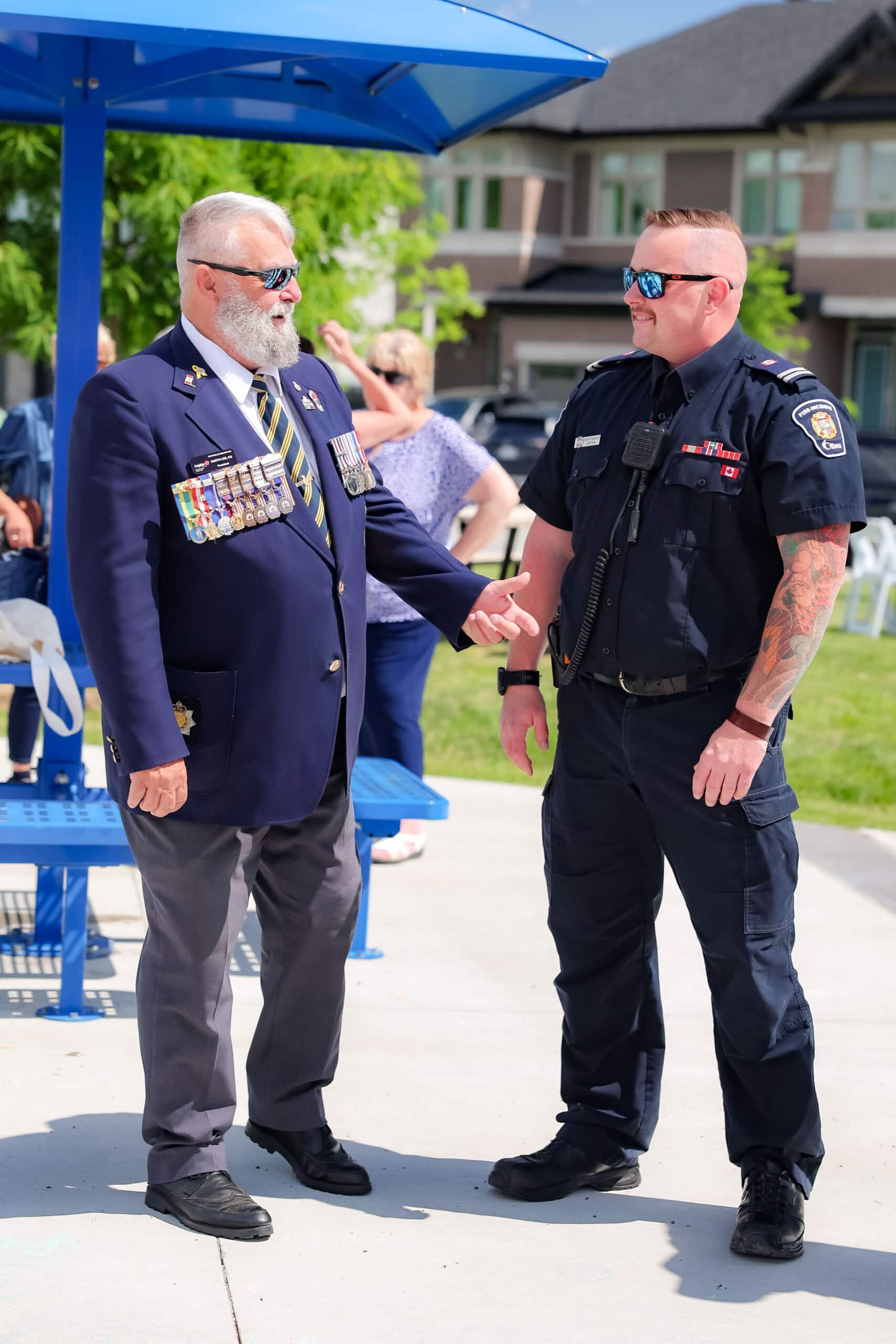 Roger Griffiths Avenue street naming ceremony. A rep from the Stittsville Legion speaks with a rep from Ottawa Fire.